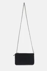 Cartera bandolera de formato rectangular en color plateado metalizado, con detalle de tachas metálicas en todo el contorno y cierre mediante cremallera.