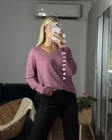 Sweater de punto color bordó con escote en V y detalle de strass aplicado en la parte frontal. Presenta mangas largas y corte holgado.