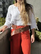 Cinturón ancho de cuero vacuno en color marrón oscuro, con hebilla decorativa de diseño orgánico en bronce.