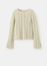 Buzo de punto medio de algodón color beige con diseño recto, detalles calados con patrón en zigzag, cuello redondo y manga larga.