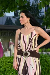 Vestido largo con estampado abstracto en tonos marrones, rosas y amarillos. Tiene breteles finos y escote en V.