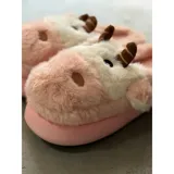 Pantuflas de peluche con diseño de vaca, confeccionadas en piel sintética suave. Cuentan con suela de goma antideslizante y diseño abierto en el talón.