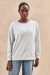 Sweater gris melange de algodón peinado con poliéster, de calce oversize, cuello redondo y mangas largas.