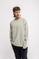 Buzo verde claro con cuello redondo, corte oversize y estampado lateral con texto en negro.