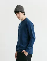 Remera de punto canalé francés con cuello polo, manga larga y cierre frontal de metal con tirador personalizado.