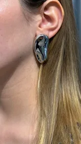 Caravana de diseño orgánico con acabado metálico brillante y forma irregular tipo gota.