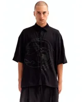 Camisa negra de manga corta con silueta oversized y estampado en el frente.
