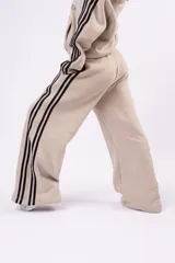 Pantalón deportivo tipo jogger de corte relajado, color negro con franjas laterales blancas y cintura elástica fruncida.