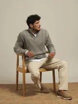 Pantalón de vestir color beige, de corte recto, con bolsillos laterales y traseros. Se ajusta a la cintura con cinturón de cuero marrón.