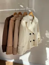 Chaqueta negra con forro tipo corderito, doble botonadura y cuello solapa.