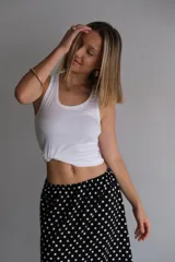 Pollera larga de fibrana color bordó con estampado de lunares blancos, tiro alto y corte amplio.