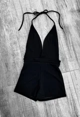 Mono corto de color rojo, con escote halter y espalda descubierta.