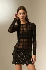 Top de manga larga confeccionado en tejido transparente con diseño de cuadros negros. Presenta un corte al cuerpo y cuello a la base.
