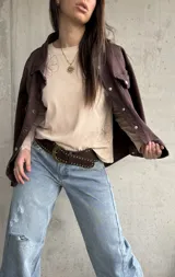 Remera manga larga de color beige, con cuello redondo y diseño bordado de flores en el hombro y lateral.
