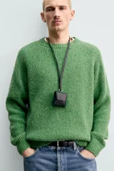 Sweater de punto perlado botonato en color marrón, corte regular fit, con cuello redondo y manga larga.