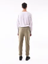 Pantalón de jogging negro, de corte ajustado con puños elásticos en los tobillos y cordón de ajuste en la cintura. Presenta paneles superpuestos en las rodillas y un pequeño texto vertical estampado en la pierna derecha.