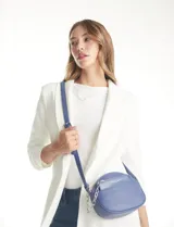 Cartera tipo bandolera de eco cuero con silueta de media luna, color beige y detalles en marrón claro. Incluye un monedero/tarjetero independiente en el bolsillo frontal y una cadena decorativa de eslabones dorados.