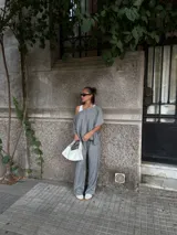 Blusa de lanilla gris con diseño asimétrico de un solo hombro y corte holgado tipo capa.