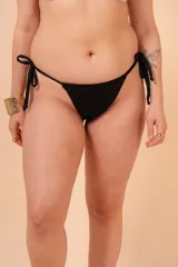 Bombacha de bikini negra de tiro medio con tiras regulables y frunce efecto levantacola.