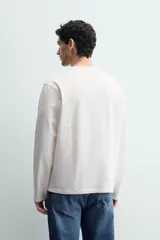 Camiseta de manga larga con corte relajado, confeccionada en tejido de algodón de peso medio, con cuello redondo acabado en rib.