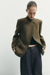 Blazer estructurado de corte recto confeccionado en tejido con lana, con estampado de cuadros en tonos tierra. Presenta cuello subido, cierre frontal con un botón, bolsillos con solapa en la parte inferior y un bolsillo de vivo en el pecho.