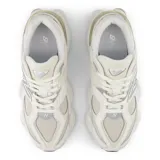 Championes urbanos New Balance modelo 9060, de diseño chunky en tonos blancos y crudos con detalles plateados. Combinan malla y superposiciones de gamuza, con la clásica "N" en el lateral y una entresuela esculpida distintiva.