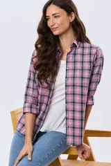 Camisa holgada a cuadros en tonos rosado, azul marino y blanco, de manga larga con puños ajustables, cuello camisero y cierre frontal de botones.