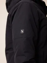 Campera de nylon negra con capucha, cierre frontal y bolsillo en el pecho con logo de la marca. Diseño acolchado con forro interior.