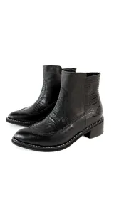 Botinetas de cuero negro con combinación de texturas lisas y grabadas tipo animal print, punta redonda, taco bajo cuadrado y costuras pespunteadas en el borde de la suela.