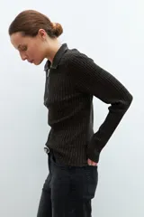 Sweater verde oliva de tejido de punto acanalado, con cuello polo, cierre metálico frontal y mangas largas.