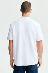 Remera polo blanca de manga corta en piqué de algodón, con cuello clásico y tapeta de dos botones.