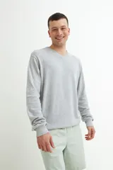 Sweater gris de punto con escote en V y mangas largas.