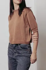 Sweater de punto color tostado con hilos metalizados, de corte recto, escote redondo y mangas cortas con puño ajustado.