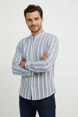 Camisa de manga larga con cuello mao y cierre frontal de botones. Presenta un diseño de rayas verticales en tonos azul y blanco.
