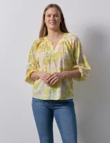 Blusa de gasa estampada con flores amarillas y blancas, cuello a la base con escote en V y mangas 3/4 fruncidas. Marca Sioni.