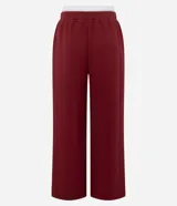 Pantalón deportivo de corte recto, confeccionado en tejido de microfibra color bordó. Presenta cintura elástica con cordón ajustable, bolsillos delanteros embutidos y detalle de bordado discreto en la pierna.