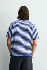 Camiseta de corte regular fit confeccionada en tejido de algodón, con diseño de rayas horizontales en color naranja y blanco, cuello redondo y manga corta.