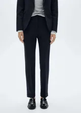 Pantalón de vestir azul marino de corte recto, tiro medio, con bolsillos laterales y traseros, y botamangas con vuelta.