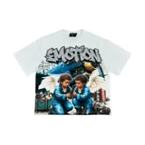 Camiseta blanca de manga corta con gran estampado frontal de estilo urbano que incluye la palabra "Emotion" en letras estilo grafiti con efecto brillante y una ilustración de dos niños con alas de ángel en un taller mecánico junto a un avión azul.