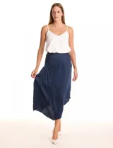 Falda midi plisada de satén color azul marino, con fruncido lateral y ruedo asimétrico.