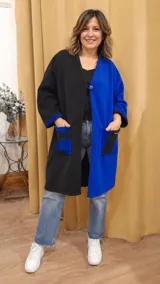 Tapado largo de lana con diseño bicolor en negro y azul. Presenta un cierre frontal con un botón, bolsillos laterales contrastantes y detalles de costuras decorativas visibles en los bordes y bolsillos.