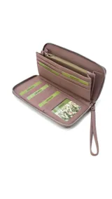 Billetera larga con cierre perimetral, confeccionada en material sintético con estampado botánico de flores silvestres sobre fondo claro. Cuenta con múltiples compartimentos internos para tarjetas, visor para documentos y un bolsillo interno con cierre. Incluye una correa de mano extraíble.