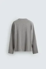 Camiseta de manga larga con corte relajado, confeccionada en tejido de algodón de peso medio, con cuello redondo acabado en rib.