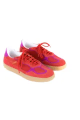 Championes de estilo retro con diseño deportivo, confeccionados en cuero vacuno y gamuza en tonos rojo y fucsia. Presentan cordones al tono, suela plana de goma en color caramelo y detalle de marca bordado en dorado en el lateral.