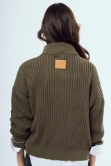 Sweater de tejido de punto color bordó, con cuello alto, cierre frontal parcial y mangas largas.