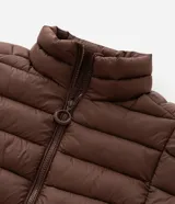 Campera puffer acolchada de corte relajado, con cuello alto, cierre frontal de cremallera y bolsillos laterales. Confeccionada en microfibra de poliamida ultraligera, resistente al agua y respirable.