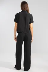 Pantalón negro de crepe con cintura elastizada, corte recto y bolsillos laterales.