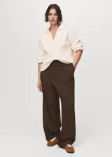 Pantalón de vestir marrón de tiro bajo y diseño wide leg, con pinzas frontales, trabillas para cinturón, bolsillos laterales y cierre oculto con botón, gancho y cremallera.