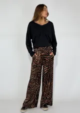Pantalón de pierna ancha con estampado de cebra en tonos marrones y negros.
