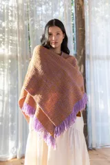 Ruana tejida con diseño de espiga en tonos lila y tostado, con terminación de flecos en color lila en todo el borde.